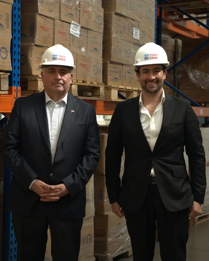 Equipo de Marea Alta con casco en la bodega, frente a pallets de productos Tres Osos y Freddo.