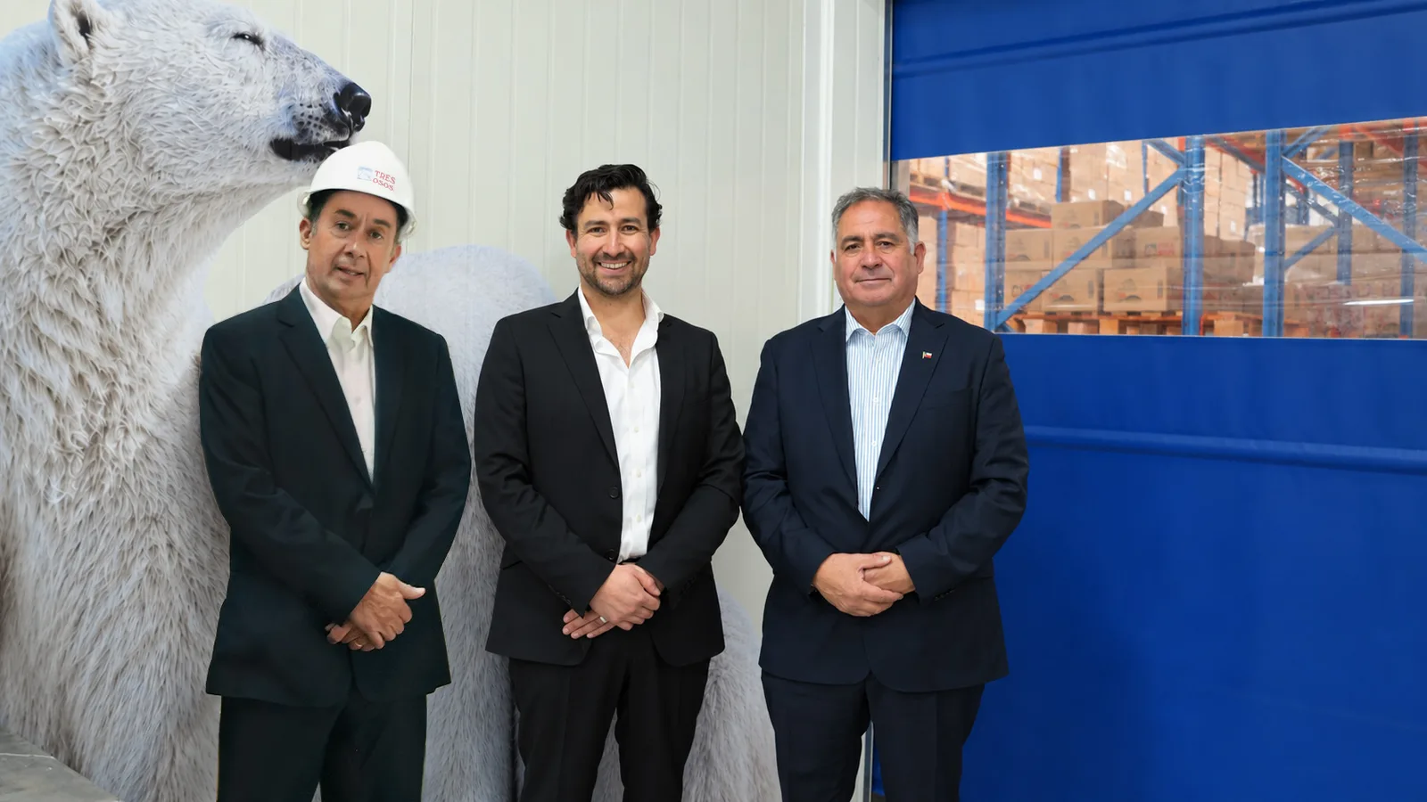 Tres integrantes de Marea Alta en la planta, frente a la figura de un oso polar y la puerta de la bodega.